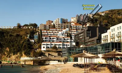 a group of buildings on a hill next to a beach at Belvedere Apartments in Budva