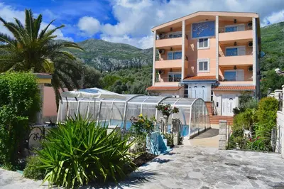 a resort with a swimming pool in front of a building at Villa Dolphin Apartments in Petrovac na Moru