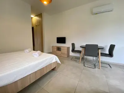 a bedroom with a bed and a table and chairs at Villa Dolphin Apartments in Petrovac na Moru