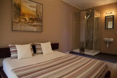 a bedroom with a bed with a glass shower at Spa Resort Luxury Apartments in Budva