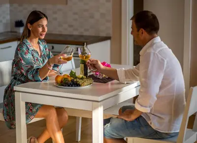 a man and woman sitting at a table with wine glasses at Spa Resort Luxury Apartments in Budva