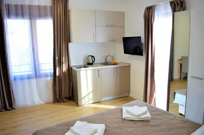 a room with a kitchen and a table with towels at Martinović Rooms in Budva