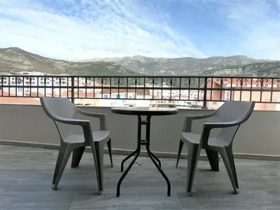 two chairs and a table on top of a balcony at Martinović Rooms in Budva