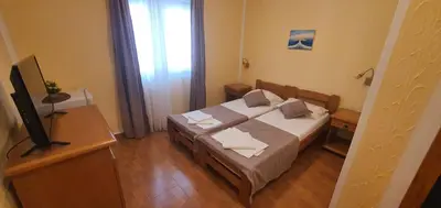 a small bedroom with a bed and a television at Martinović Rooms in Budva