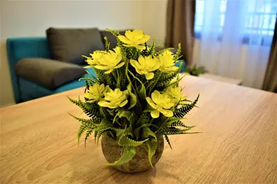 a vase filled with yellow flowers on a table at Martinović Rooms in Budva