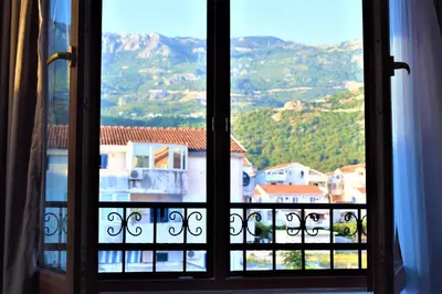 an open window with a view of a mountain at Martinović Rooms in Budva