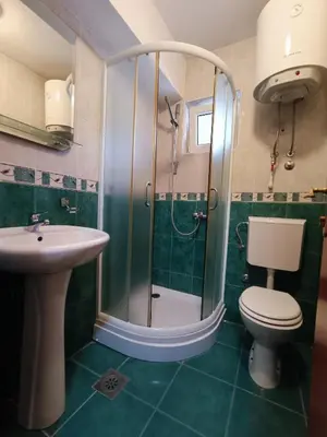 a bathroom with a shower and a toilet and a sink at Martinović Rooms in Budva