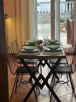a wooden table with green plates and glasses on it at Sirena Marta in Sutomore