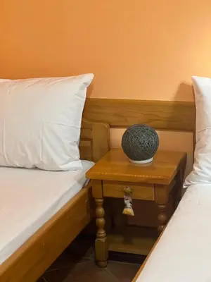 a room with two beds and a table with a bowl on it at Sirena Marta in Sutomore