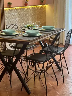 a wooden table with chairs and plates and glasses on it at Sirena Marta in Sutomore