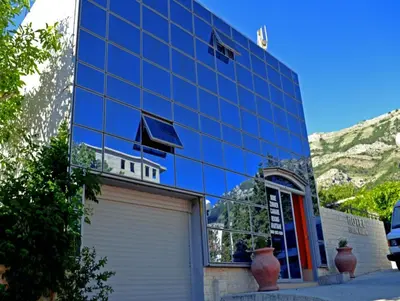 a glass building with a garage in front of it at Sirena Marta in Sutomore