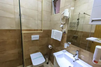 a bathroom with a toilet and a sink and a shower at Sirena Marta in Sutomore
