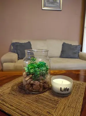 a vase with a plant and a candle on a table at Center 1 Podgorica in Podgorica