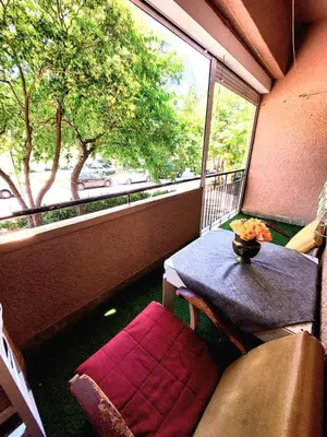 a table and a chair in a balcony with a window at Center 1 Podgorica in Podgorica