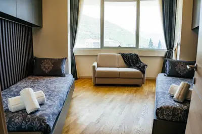 a room with two beds and a couch and a window at Luxury Apartment Budva in Budva
