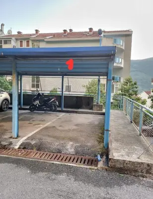 a motorcycle parked in a parking lot next to a building at BLUE EYES SAILORS in Kotor