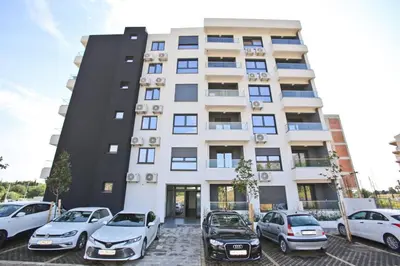 a building with cars parked in front of it at Lux Stanovi Vucetic in Bar