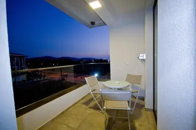 a room with a balcony with a table and chairs at Lux Stanovi Vucetic in Bar