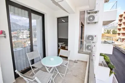 a small apartment with a table and chairs on a balcony at Lux Stanovi Vucetic in Bar