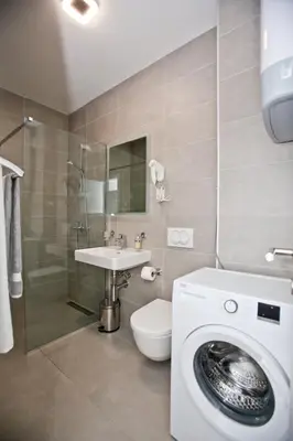a bathroom with a washing machine and a sink at Lux Stanovi Vucetic in Bar