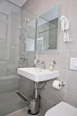 a bathroom with a sink and a toilet and a mirror at Lux Stanovi Vucetic in Bar