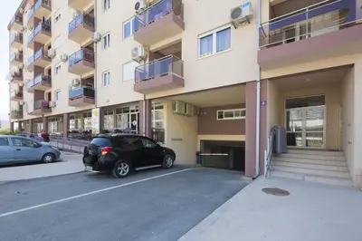a car parked in a parking lot in front of a building at Apartment Ana in Budva