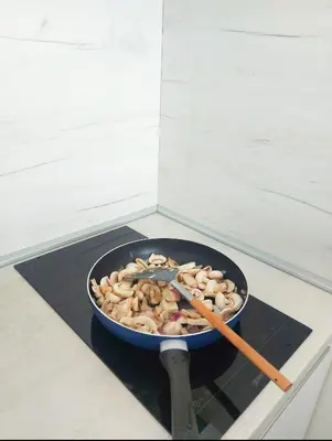 a pan of food on a stove with two chopsticks at Artemis Apartment in Ulcinj