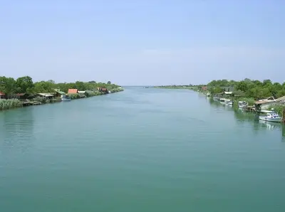 a river with houses and boats in the water at Artemis Apartment in Ulcinj