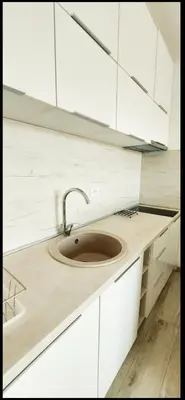 a kitchen with a sink and white cabinets at Artemis Apartment in Ulcinj