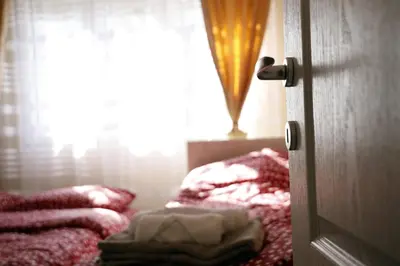 a bedroom door with a bed and a window at Apartment Alexandar in Podgorica