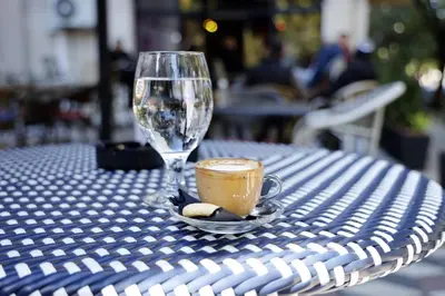 a cup of coffee and a wine glass on a table at Apartment Alexandar in Podgorica
