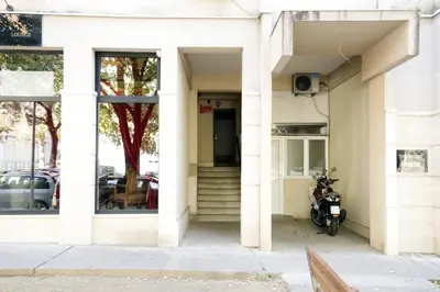 a motorcycle parked outside of a white building at Apartment Alexandar in Podgorica