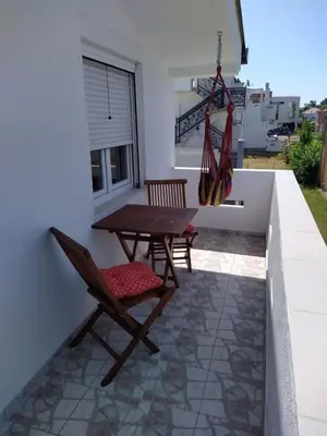 a patio with a wooden table and chairs on a balcony at House Munich - Montenegro in Donji Štoj