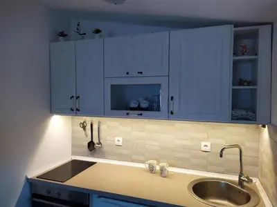 a kitchen with blue cabinets and a sink at House Munich - Montenegro in Donji Štoj