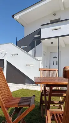 a wooden picnic table and two chairs in front of a house at House Munich - Montenegro in Donji Štoj