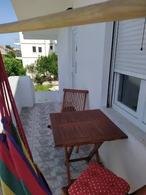 a porch with a wooden table and a hammock at House Munich - Montenegro in Donji Štoj