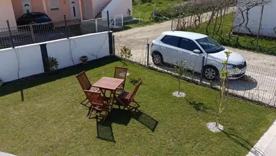 a car parked in a yard with a table and chairs at House Munich - Montenegro in Donji Štoj