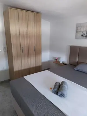 a bedroom with a large bed and a wooden cabinet at House Munich - Montenegro in Donji Štoj