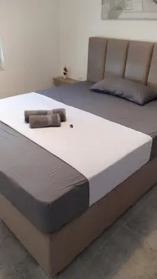 two beds in a room with avertisement at House Munich - Montenegro in Donji Štoj