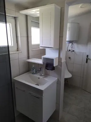 a white bathroom with a sink and a mirror at House Munich - Montenegro in Donji Štoj