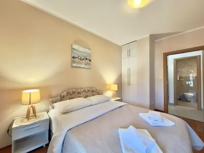 a bedroom with a large white bed and a window at Beachfront Apartments Oaza 2 in Petrovac na Moru