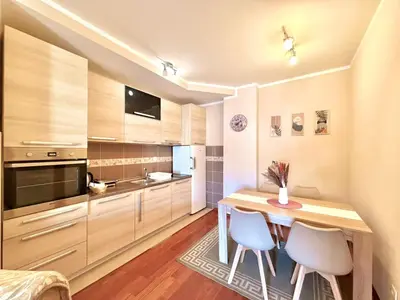 a small kitchen with a wooden table and chairs at Beachfront Apartments Oaza 2 in Petrovac na Moru