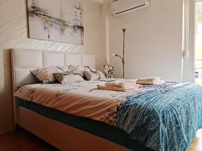 a bedroom with a large bed with a white headboard at Apartman Elijana in Budva
