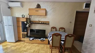 a kitchen with a table with chairs and a television at Apartman Elijana in Budva