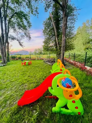 a toy dinosaur on the grass in a park at Garden Villas in Donji Štoj