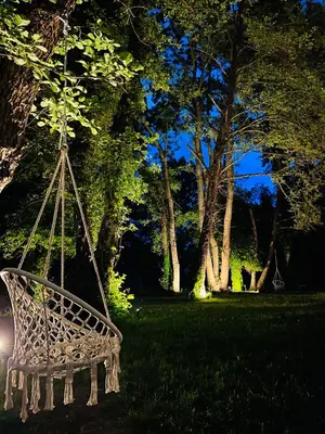 a swing in a park with trees in the background at Garden Villas in Donji Štoj
