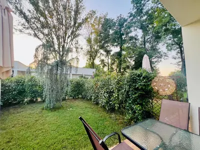 a patio with a table and chairs in a yard at Garden Villas in Donji Štoj