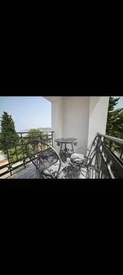 a table and chairs on a balcony with the ocean at Villa M in Dobra Voda