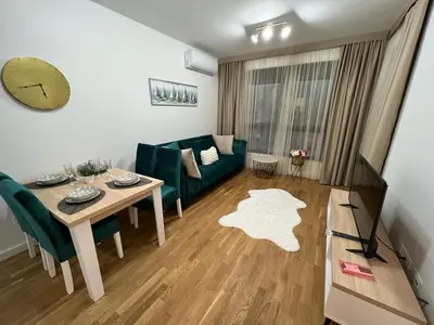 a living room with a table and a green couch at Corall apartment Bar in Bar