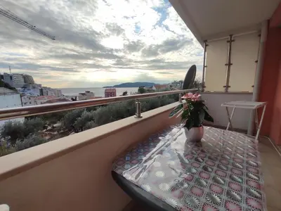 a balcony with a table and a vase of flowers at Apartmani Tomić 4* in Rafailovici